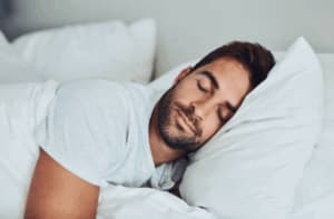 Uomo che dorme serenamente su un cuscino bianco