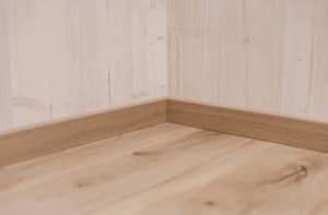 Angolo stanza con pavimento e battiscopa in legno